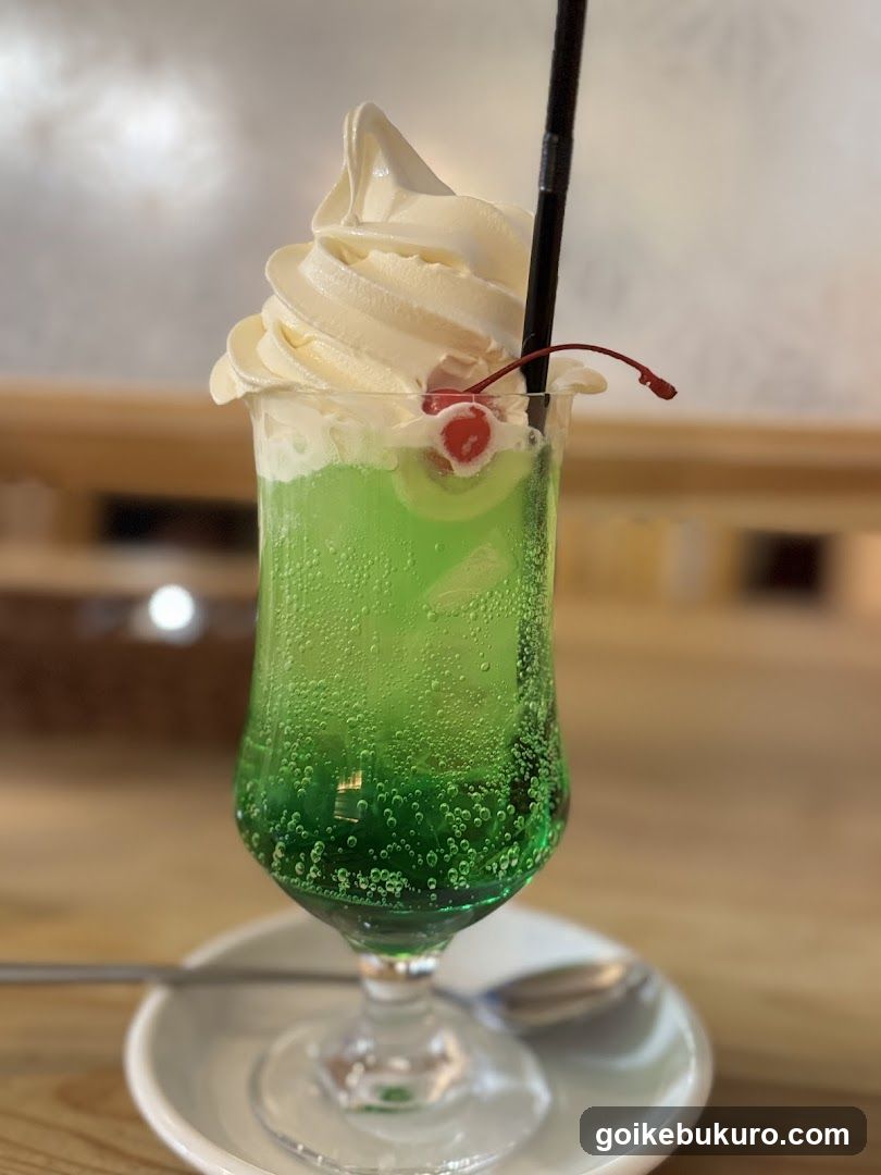 Green Cocktail with Whipped Cream and Cherry