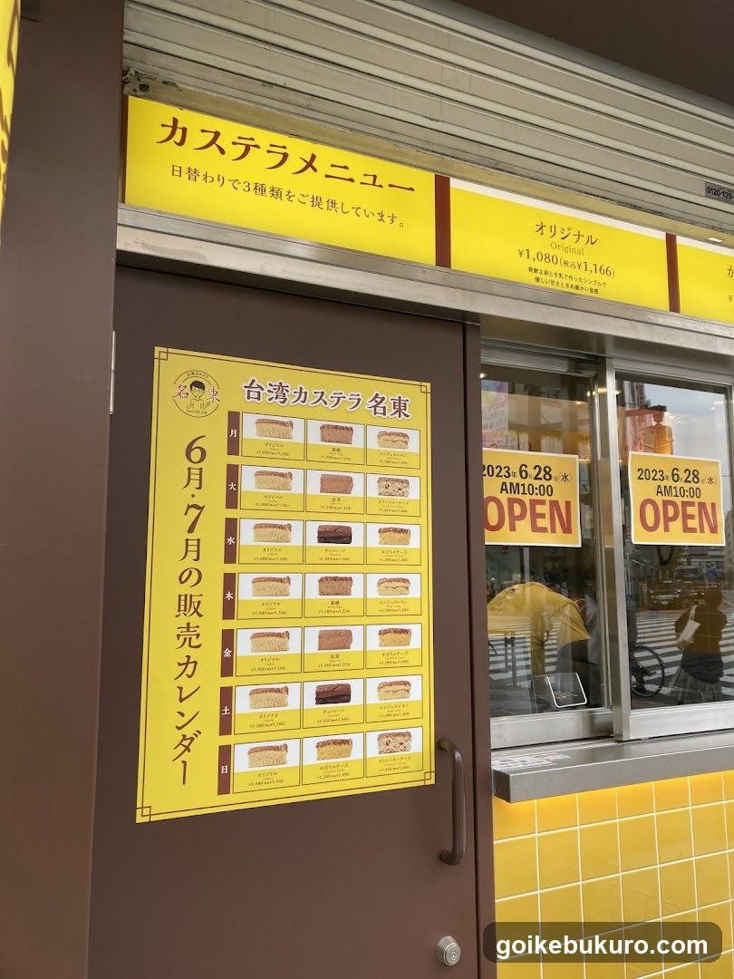 A shop front with a yellow signboard displaying 'Custard Menu' and 'Original ¥1,080 to ¥1,166'. A large poster on the door lists 'Taiwan Custard Name East' with a schedule of custards for June and July. The window shows an 'OPEN' sign dated June 28, AM 10:00.