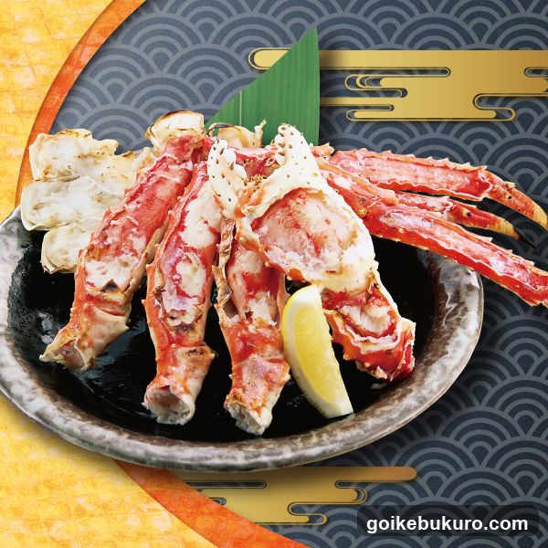 A plate of king crab legs and meat, garnished with lemon slices and a green leaf, presented on a dark ceramic dish against a stylized Japanese wave background.