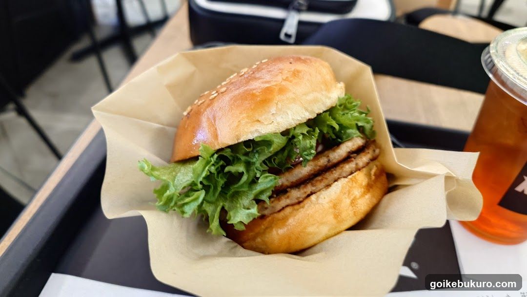 Burger with lettuce and fried patty in paper wrapper