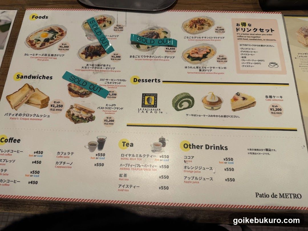 A printed menu from Patio de METRO, featuring sections for Foods (including a sold-out Caesar Salad), Sandwiches (with a sold-out Croque Monsieur), Desserts (showing various cakes and pastries), Coffee, Tea, and Other Drinks. Prices are listed in yen.