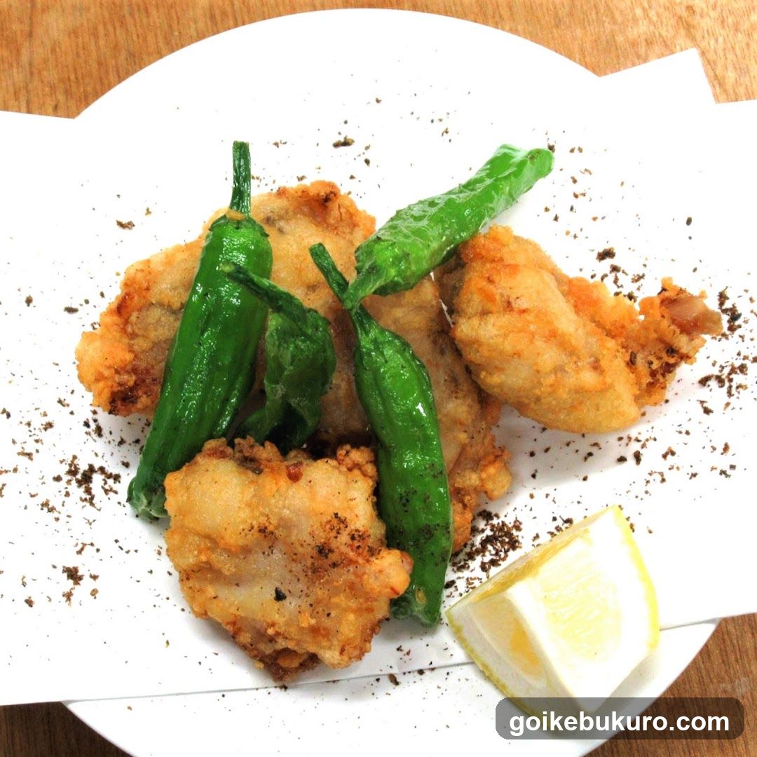 Fried Chicken with Shishito Peppers and Lemon Wedge