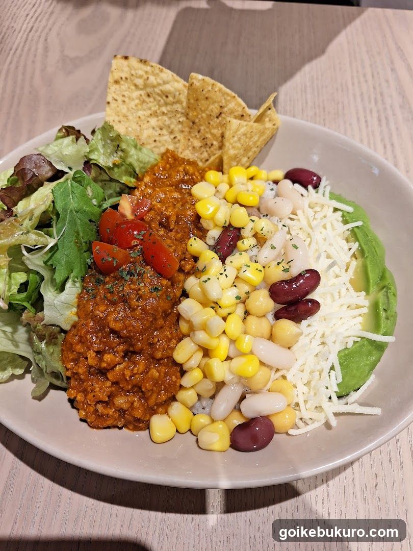 Bowl of Mexican-inspired food with salad and chips