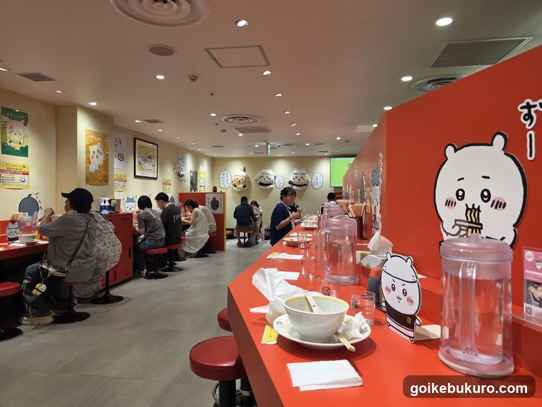 Interior of a Japanese ramen restaurant with cartoon characters on walls and tables.