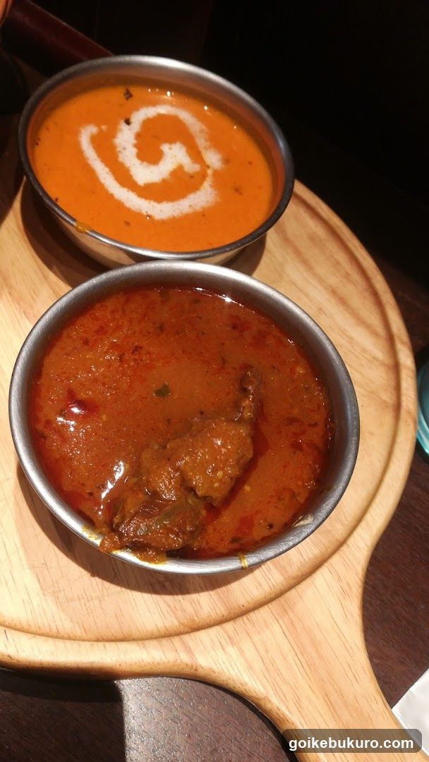 Two Bowls of Curry on Wooden Board