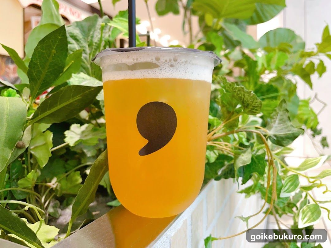 Yellow beverage in cup with greenery background