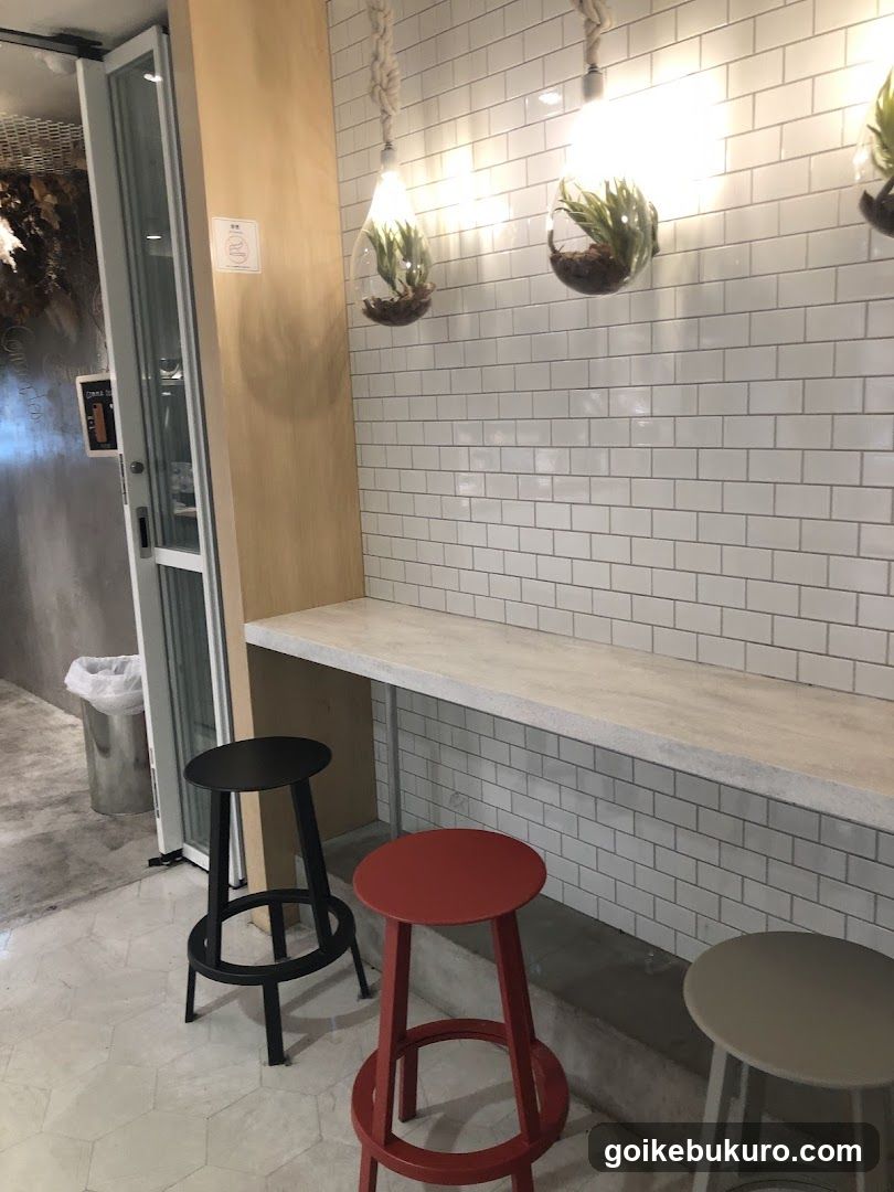 Interior seating area with white subway tiles and hanging plants